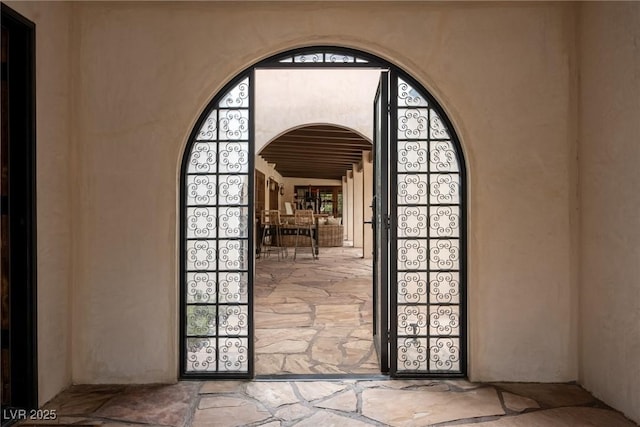 entryway with stone floors and arched walkways