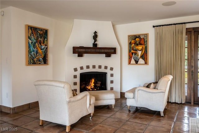 living area with a large fireplace and baseboards