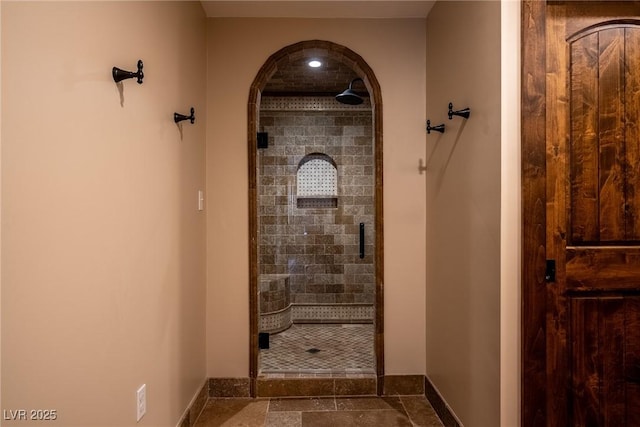 full bathroom featuring a stall shower, baseboards, stone finish flooring, and recessed lighting