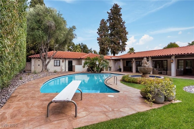 swimming pool with a patio area and a diving board