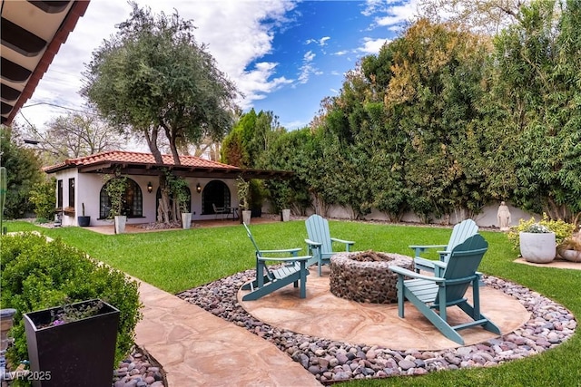 view of grassy yard featuring a fire pit and a patio area