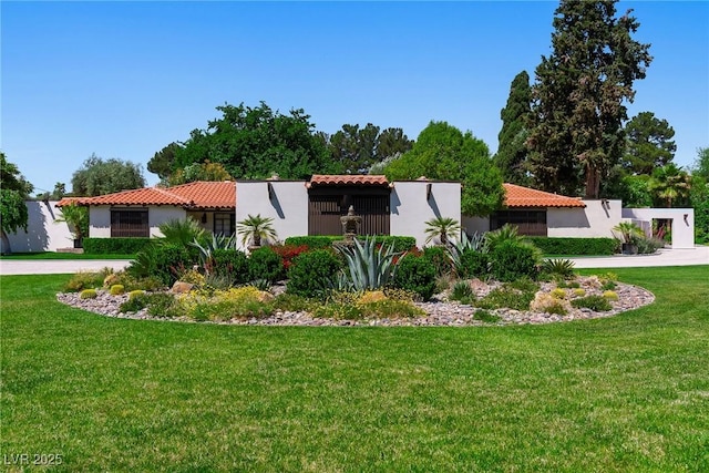 view of side of property featuring a yard, stucco siding, a tiled roof, and driveway