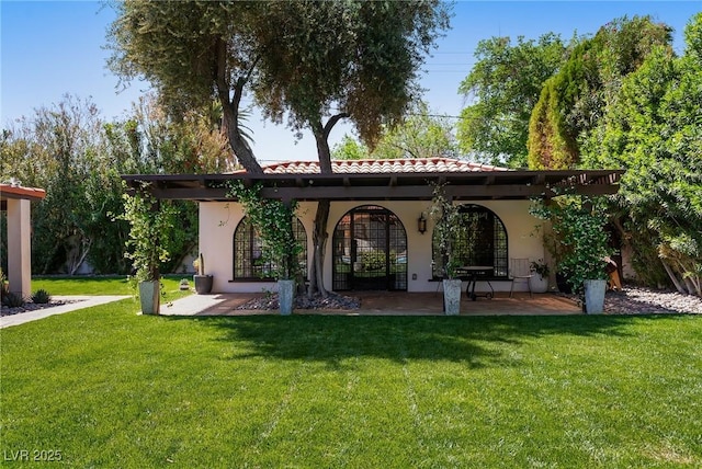 rear view of property featuring a yard and stucco siding