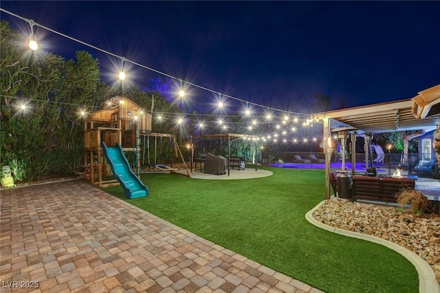 yard at twilight with a pool and a playground