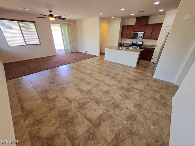 kitchen with a sink, open floor plan, appliances with stainless steel finishes, visible vents, and recessed lighting