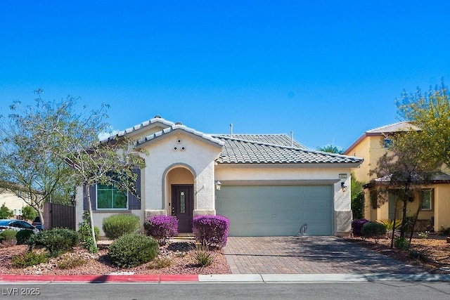 4032 Little Bay Ave, North Las Vegas, NV 89081 - mediterranean / spanish-style house featuring an attached garage, a tiled roof, stucco siding, and decorative driveway
