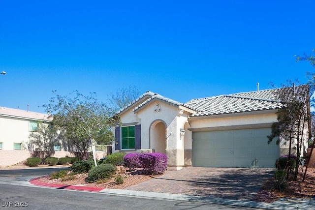 4032 Little Bay Ave, North Las Vegas, NV 89081 - mediterranean / spanish-style house with stucco siding, an attached garage, a tile roof, and decorative driveway