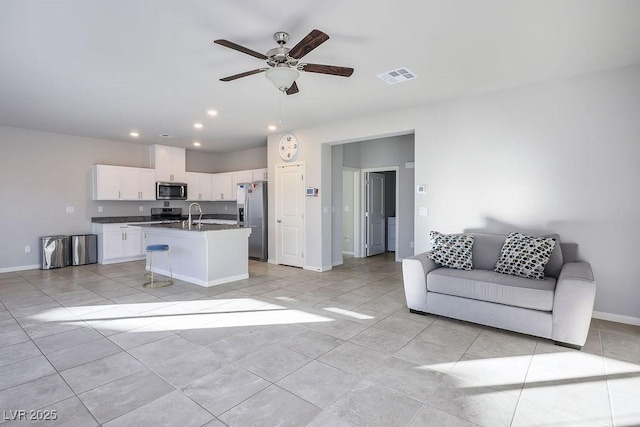 9871 Magnus Ct, Las Vegas, NV 89178 - kitchen featuring stainless steel appliances, open floor plan, dark countertops, white cabinets, and recessed lighting