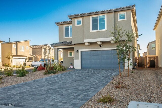 9871 Magnus Ct, Las Vegas, NV 89178 - view of front facade with stucco siding, an attached garage, a tiled roof, and decorative driveway