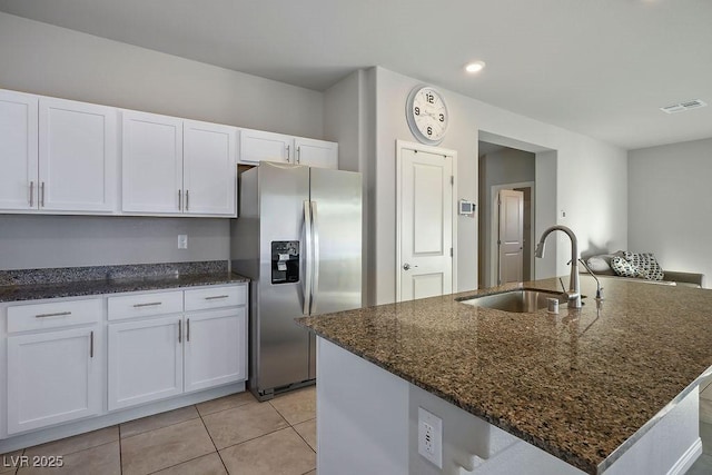 9871 Magnus Ct, Las Vegas, NV 89178 - kitchen featuring stainless steel refrigerator with ice dispenser, a sink, white cabinets, dark stone counters, and light tile patterned floors