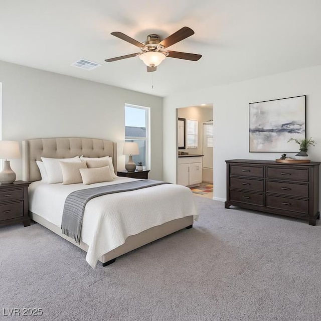 9871 Magnus Ct, Las Vegas, NV 89178 - bedroom featuring light colored carpet, a ceiling fan, ensuite bath, and baseboards