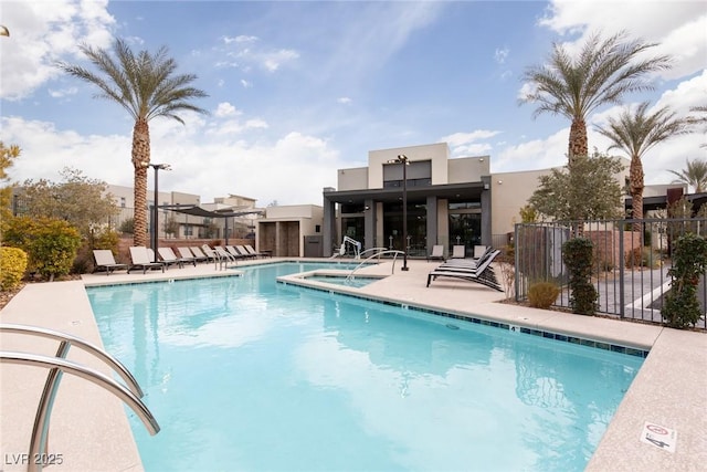 pool featuring fence, a community hot tub, and a patio area