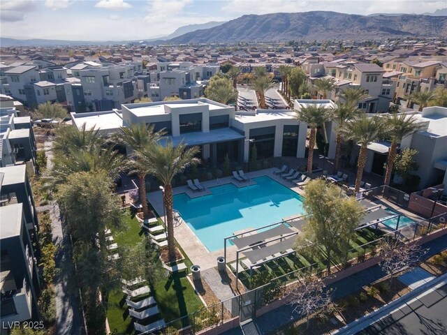 pool with a residential view, a mountain view, and a patio area