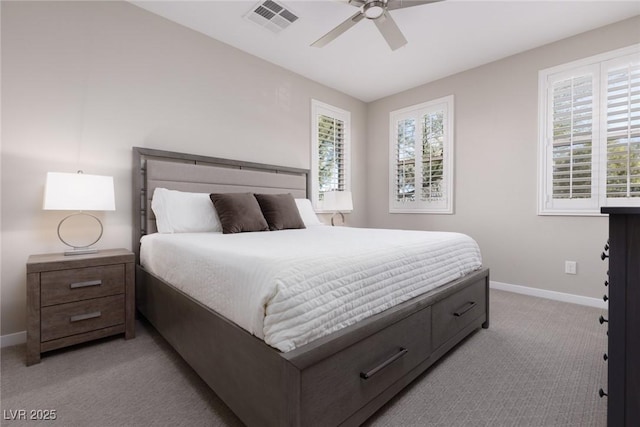 bedroom featuring light carpet, multiple windows, visible vents, and baseboards