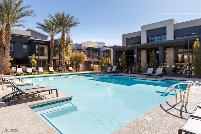 pool with a patio and fence