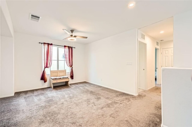 carpeted spare room featuring visible vents, baseboards, and a ceiling fan