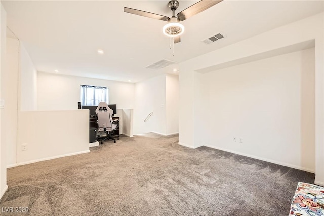unfurnished office with carpet floors, ceiling fan, visible vents, and baseboards