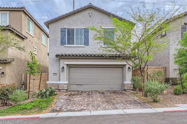 traditional home with a tiled roof, stucco siding, decorative driveway, stone siding, and an attached garage