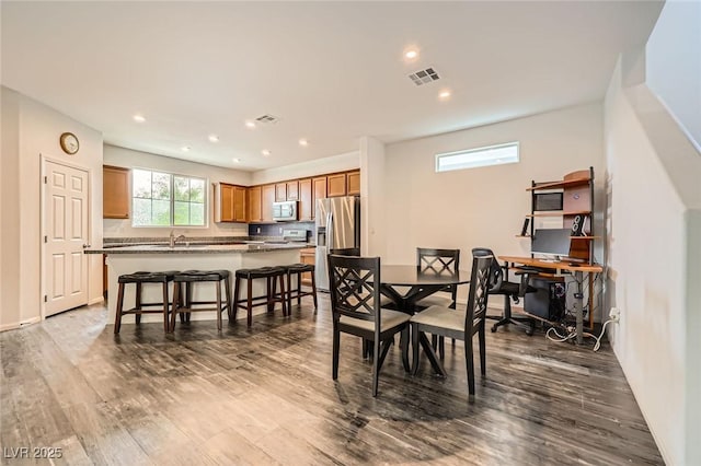 dining space with dark wood-style floors, visible vents, and recessed lighting