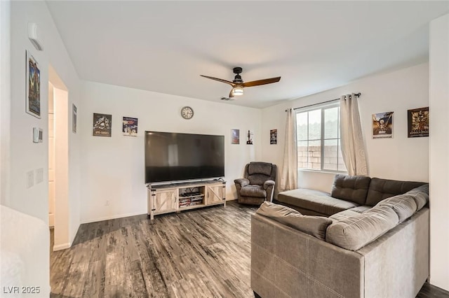 living area with visible vents, baseboards, a ceiling fan, and wood finished floors