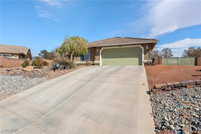 view of front of property featuring concrete driveway, stucco siding, an attached garage, a tile roof, and fence