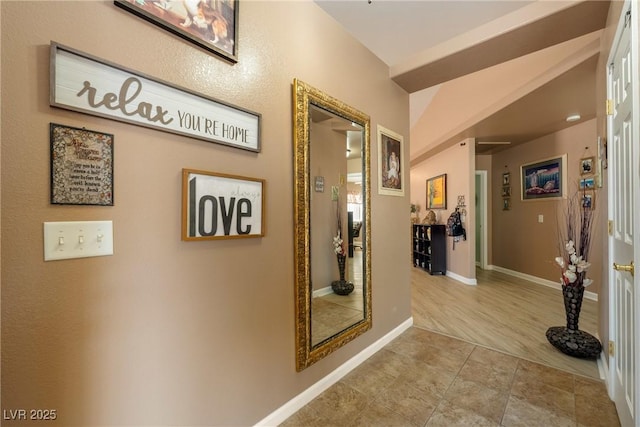 hallway with tile patterned floors and baseboards