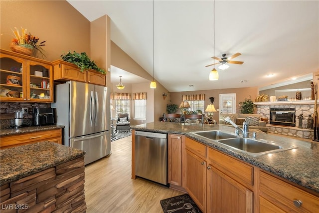 kitchen featuring vaulted ceiling, open floor plan, ceiling fan, stainless steel appliances, and a sink