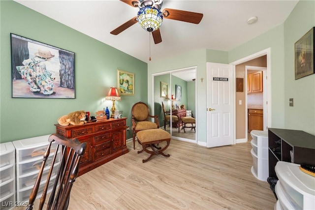 sitting room with light wood-style floors, baseboards, and a ceiling fan