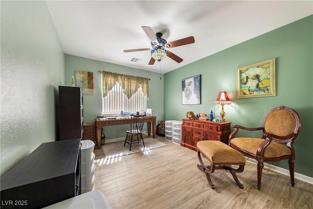 interior space with visible vents, baseboards, a ceiling fan, and wood finished floors