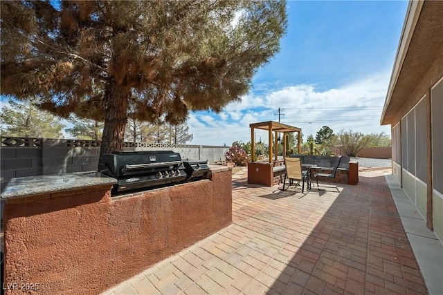 view of patio with exterior kitchen, outdoor dining area, a grill, and fence