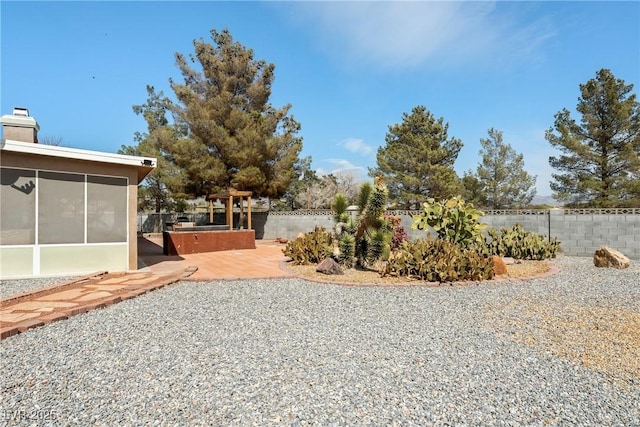 view of yard featuring a patio, a sunroom, and fence