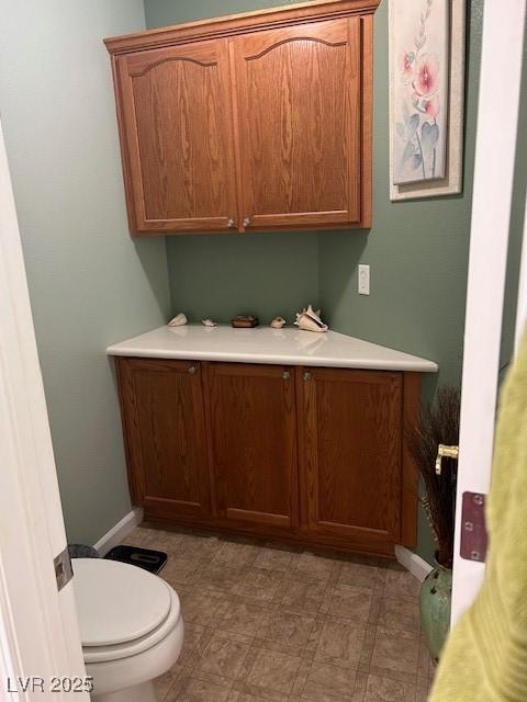 bathroom featuring toilet, tile patterned floors, and baseboards