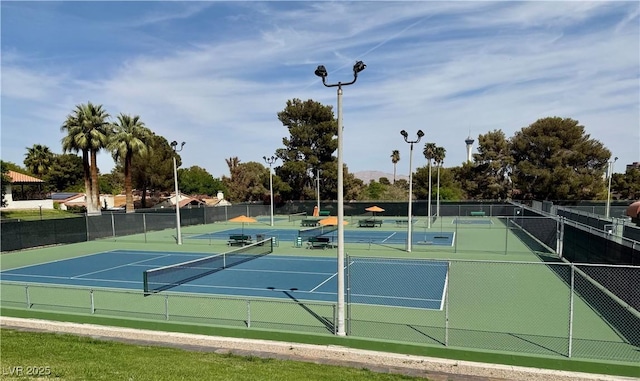 view of tennis court featuring community basketball court and fence