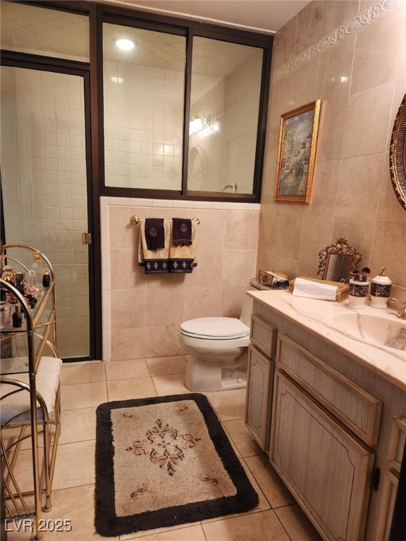 bathroom featuring toilet, tile walls, and tile patterned flooring