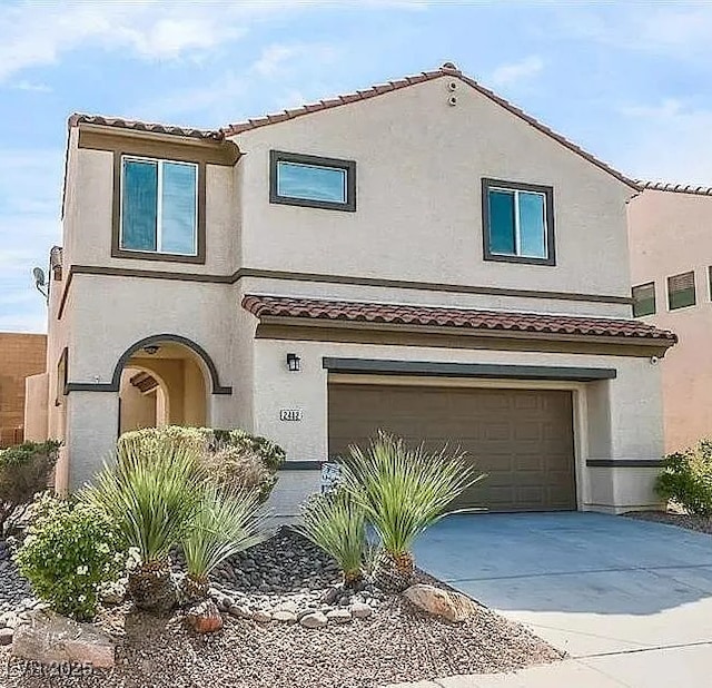view of front of house with stucco siding, an attached garage, a tiled roof, and driveway