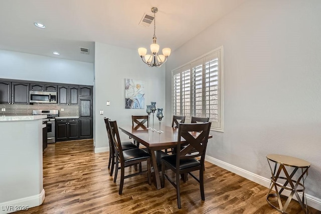 dining room featuring a chandelier, dark wood-type flooring, visible vents, and baseboards