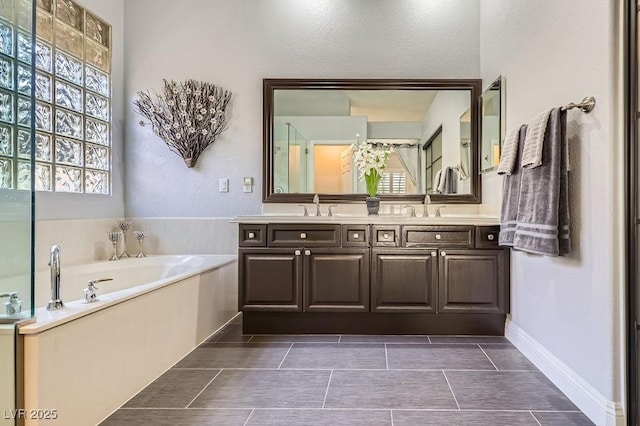 bathroom featuring double vanity, a bath, and a sink