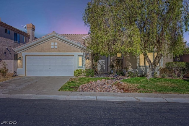 view of front of property featuring a garage, driveway, stucco siding, and a tile roof