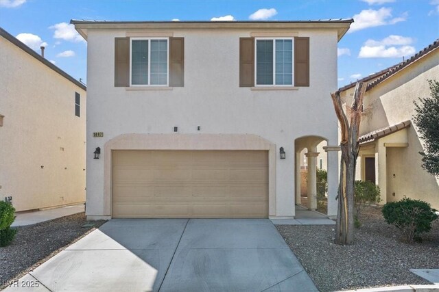 view of front facade featuring stucco siding, driveway, and a garage