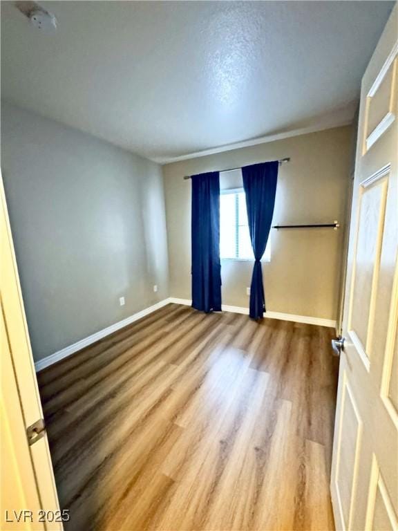 5250 S Rainbow Blvd Unit 1131, Las Vegas, NV 89118 - empty room featuring baseboards, wood finished floors, and crown molding