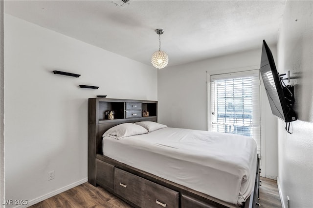 bedroom featuring baseboards and dark wood-style floors