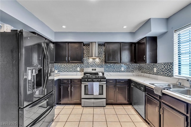 kitchen with wall chimney exhaust hood, stainless steel appliances, a wealth of natural light, and light tile patterned floors