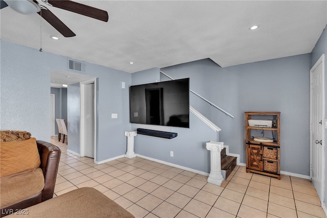 living area with visible vents, stairs, ceiling fan, and light tile patterned flooring