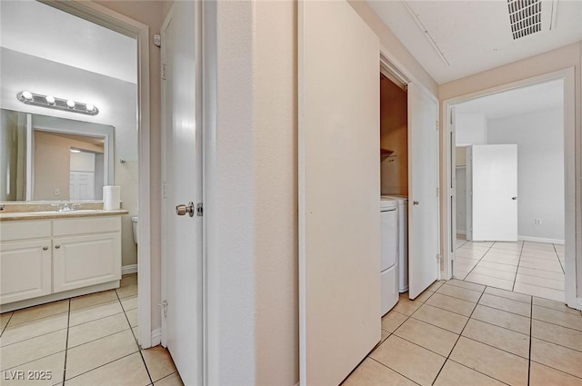 1881 W Alexander Rd Unit 1135, North Las Vegas, NV 89032 - corridor featuring light tile patterned flooring, visible vents, independent washer and dryer, and a sink