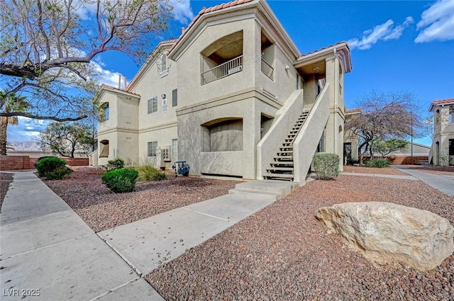 1881 W Alexander Rd Unit 1135, North Las Vegas, NV 89032 - view of front of house with a tile roof, stucco siding, and stairs