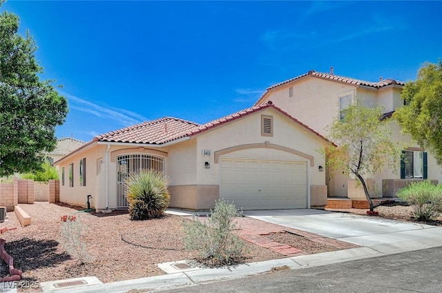 mediterranean / spanish house featuring a garage, a tile roof, concrete driveway, and stucco siding