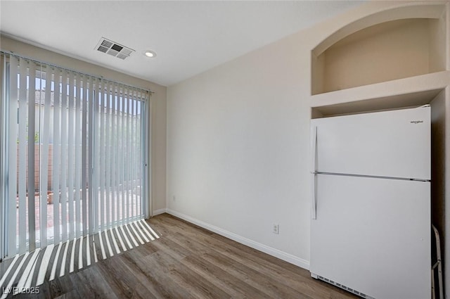 unfurnished dining area with baseboards, wood finished floors, visible vents, and recessed lighting