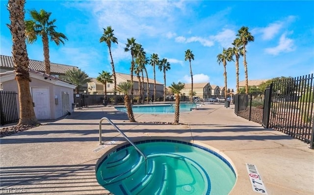 pool featuring a residential view, a patio area, fence, and a hot tub