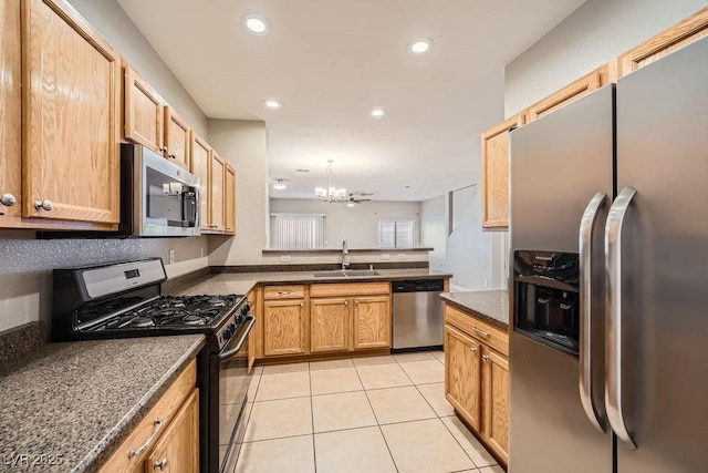kitchen featuring an inviting chandelier, a peninsula, recessed lighting, a sink, and stainless steel appliances