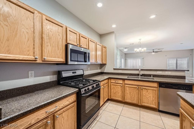 kitchen with dark countertops, a sink, and stainless steel appliances